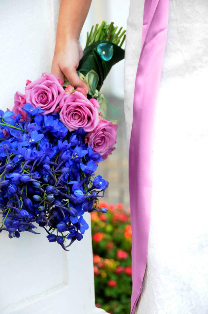 Beautiful romantic bouquet made of bright blue delphiniums and purple roses