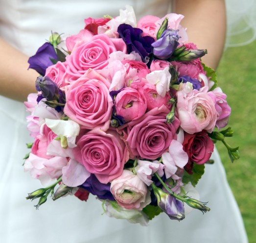 A bouquet made of pink ranunculus pink and purple roses with purple