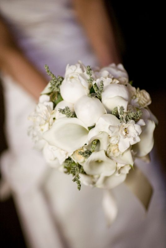 An amazing white bridal bouquet made up of white peonies gardenias and 