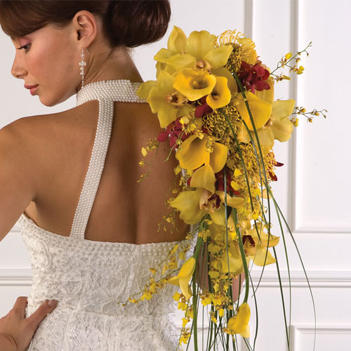 Cascading yellow bouquet of orchids and calla lilies