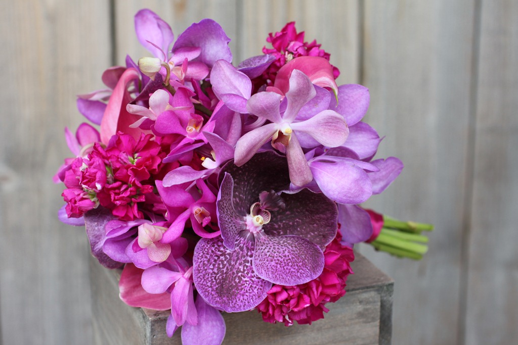 purple hydrangea, plum stock, deep purple calla lilies, and lavender mokara orchids with bright and fluttery accents of purple vanda, raspberry dendrobium, and fuchsia phalaenopsis orchid blooms 1