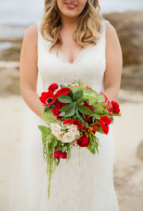 Red bouquet of ranunculus and roses, accented with white blooms and greenery