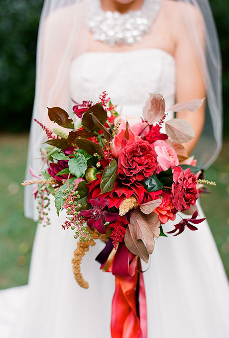 Red roses, clematis, and astilbe accented with colorful greenery