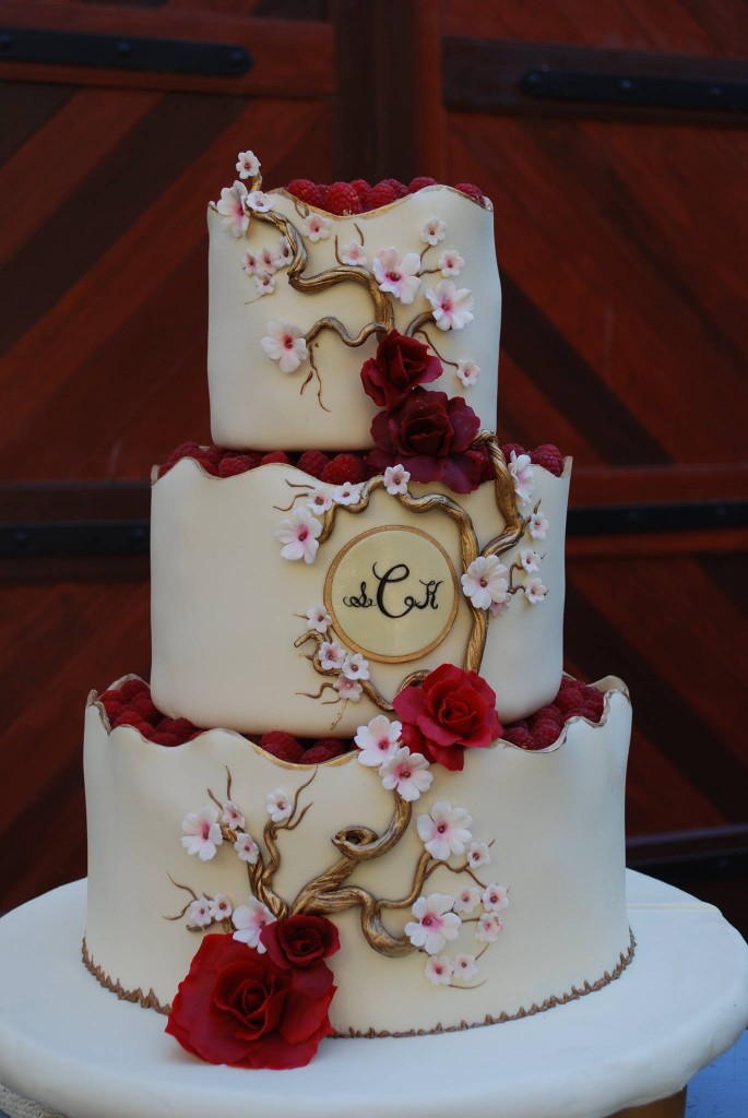 three tier wedding cake white with berries and blossoms