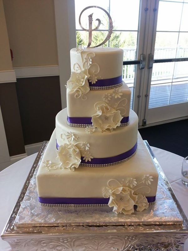 white wedding cake with deep purple satin ribbon