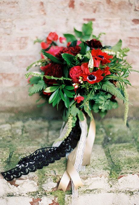 Red bridal bouquet of garden roses, anemones, berries, and greenery