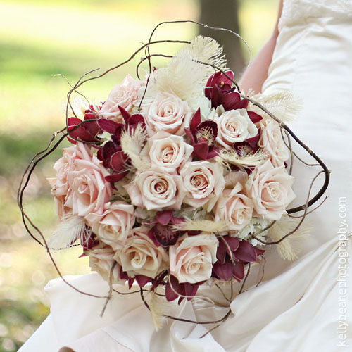 Sahara roses, white hydrangea, mini burgundy Cymbidium orchids, Ostrich feathers